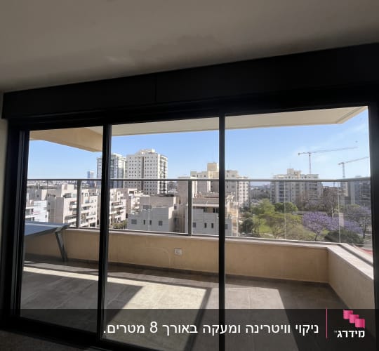 מרפסת עם נוף לעיר דרך חלון זכוכית גדול